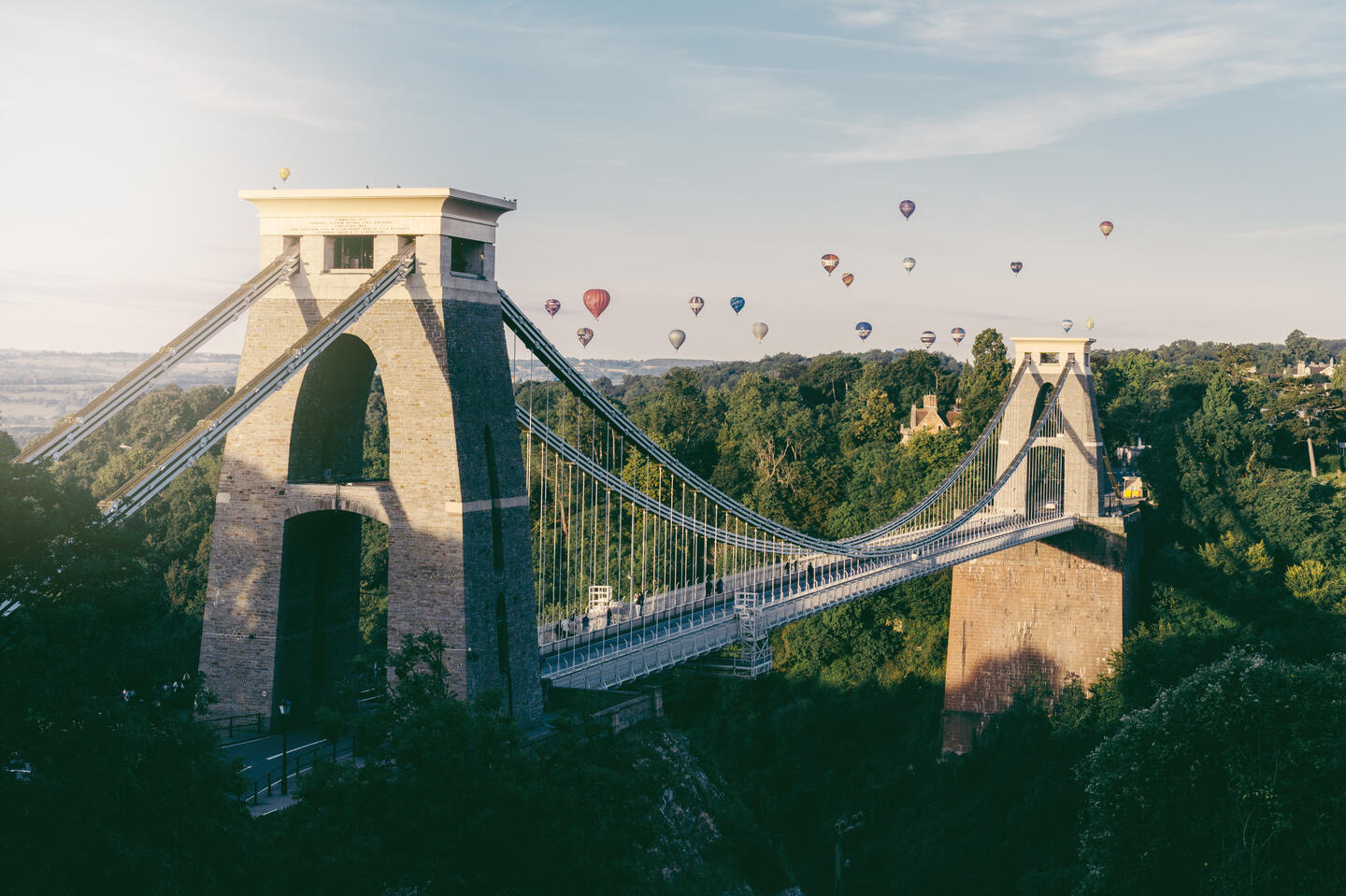A photo of Clifton Suspension Bridge with a large number of hot air balloons in the background.